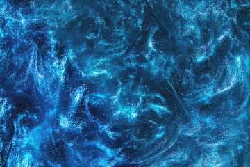 Abstract elegant, detailed blue glitter particles flow with shallow depth of field underwater....