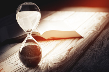 Closed up of sandglass or hourglass on background of book