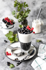 Fresh currants in a ceramic cup: black currants, red currants, selective focus. Place for text