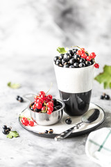Fresh currants in a ceramic cup: black currants, red currants, selective focus. Place for text. Copy space