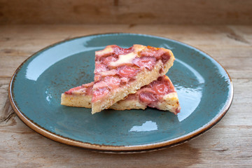 Round strawberry pie with fresh strawberries slice on plate dish on wooden table background
