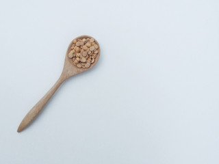 The soybeans are on wooden spoon with the white background.