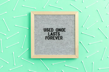 Pattern made of cotton swabs on mint background. Letterboard with quote Used once lasts forever