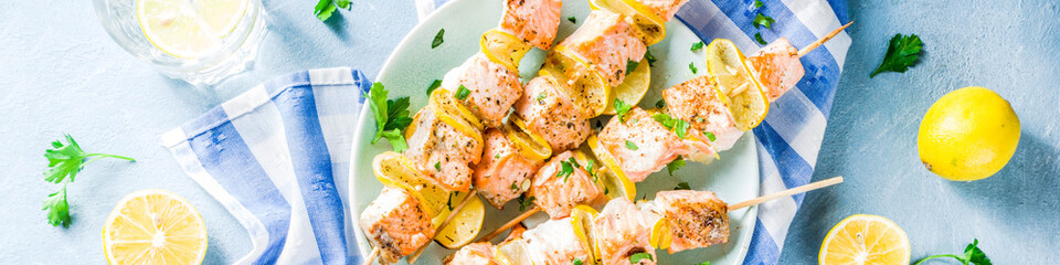 Homemade salmon fish grilled skewers, with lemon and greens