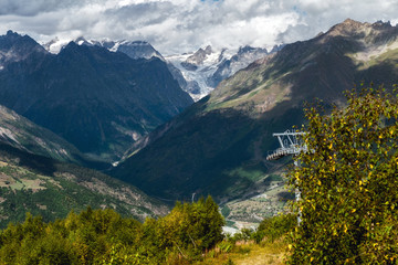 Fototapeta na wymiar ropeway down from Hatsvali Ski resort to Mestia with mountain Shkhara and its glacier on background