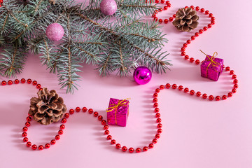 Blue spruce on a pink background with Christmas toys