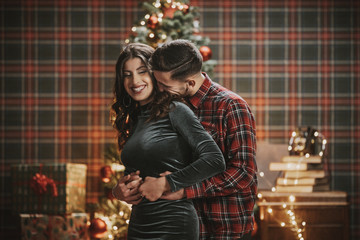 Young couple celebrating Christmas in under the tree