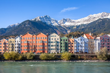 Fototapeta na wymiar Panoramic view of famous colourful houses and snow-capped alpine mountain tops in the background in the historic city center of scenic Innsbruck on a beautiful sunny day with blue sky, Tyrol, Austria
