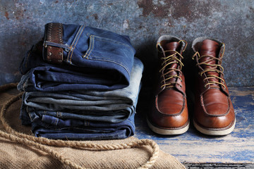 Old blue jeans and safety shoes on rustic background, Old blue jeans and safety shoes in a store
