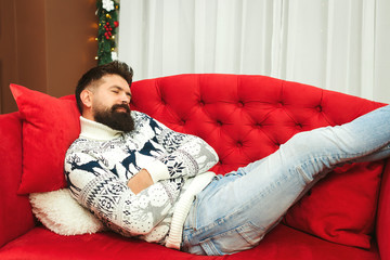 Handsome man tired while preparation christmas gifts. Christmas holidays. Young father sleeping at...
