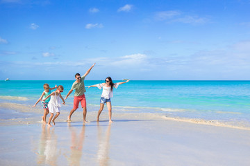 Happy beautiful family of four on the beach