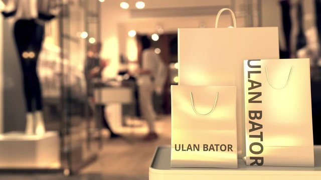 Shopping bags with Ulan Bator caption against blurred store entrance. Shopping in Mongolia related 3D animation