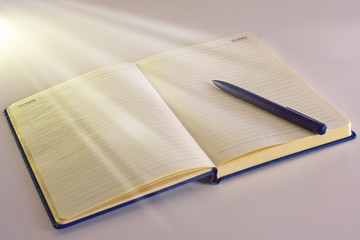 Opened notebook for tasks with pen and blank pages.