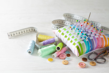 Needle box, threads and cotton fabrics for sewing. White background.