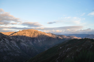Obraz premium Golden hour in the mountains. The top of the mountain is illuminated by the sun. Geres. Portugal. Nature.