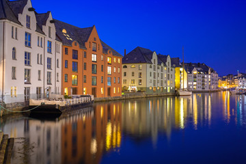 Obraz premium Architecture of Alesund city reflected in the water at night, Norway