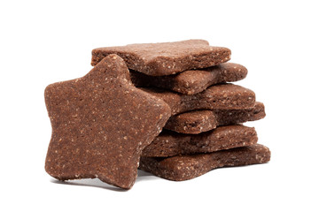 Delicious homemade chocolate and sugar cookies in the shape of stars, piled up on top of each other and one stands nearby, isolated on a white background. Christmas baking for the whole family