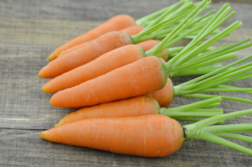 Fresh leafless carrots on wooden background, closeup