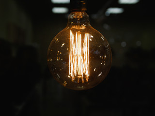 round incandescent lamp. Vintage stylized round tungsten lamp. Glowing in the dark, close-up photo...