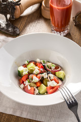 Fresh Greek salad in bowl with olives tomato feta cheese cucumber and onion on textile napkin