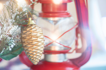 Beautiful Christmas decoration. Christmas tree branch pine cone, on red lamp and abstract glitter background.
