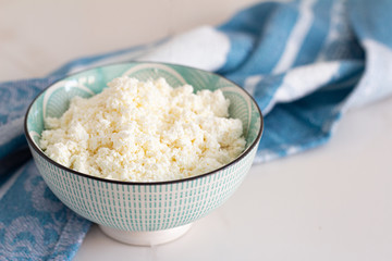 cup of cottage cheese in a cup on a white background close-up