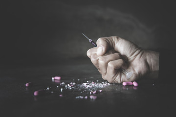 Stop drug addiction concept. A human hand holding a needle for heroin . International Day against...