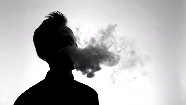 silhouette of man using an electric cigarette