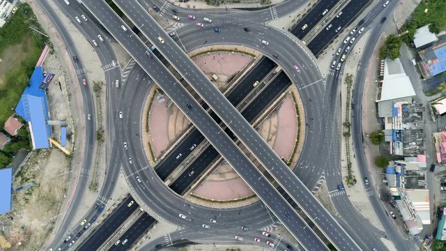 timelapse of day city traffic on 4-way stop street intersection circle roundabout in bangkok, thailand. 4K UHD horizontal aerial view.