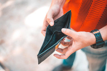 Young man holding his empty wallet