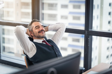 happy young businessman work in modern office relaxing in chair, lifestyle after work at office sitting hands behind head for happy businessmen people