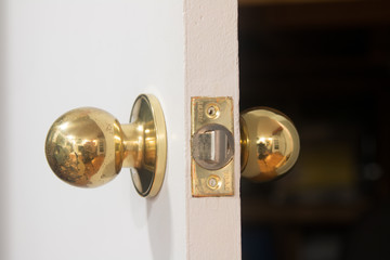 door handle and lock of gold color on a white door
