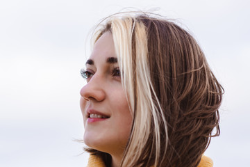 portrait of beautiful young woman in yellow pullover sweater on the beach