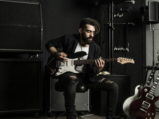 Man playing his electric guitar in a music studio