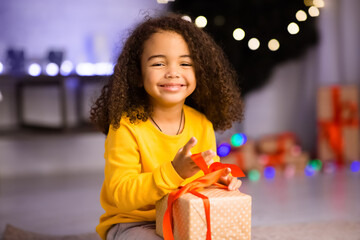 Adorable african american kid enjoying Christmas gift at home