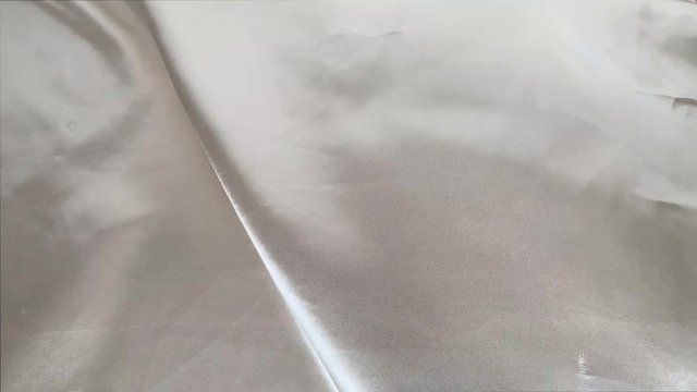 beautiful silk fabric of white color, draped with small folds, softly flowing, luxury, wedding concept, texture, background, form for a card, copy space