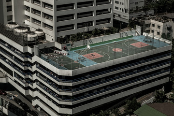 Aerial of colorful basketball courts on the rooftop of a Parking lot building in bangkok.