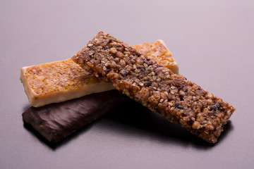 Fitness bars on a dark background. Fitness bars with different filling. Chocolate fitness bars close-up.
