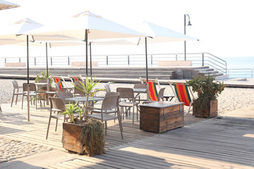 outdoor bar with chairs, table and sun umbrella near the sea with copy space for your text