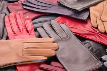 Background of many scattered gloves. Women leather gloves.A collection of colored leather gloves.