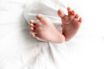 newborn baby feet in bed