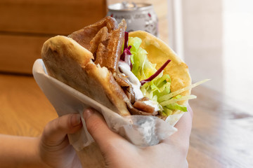 Girl holding a delicious doner in her hands / Girl eating a doner