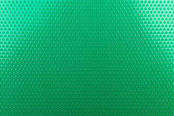 Real texture made of green rubber rhombus close up, illuminated with light.