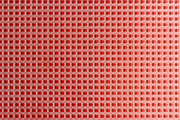 Real texture of pink rubber squares close up, illuminated with light.