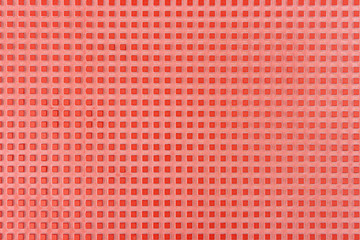 Real texture of pink rubber squares close up, illuminated with light.