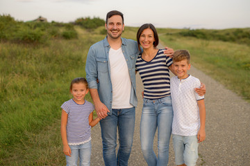 Fototapeta premium Shot of a family of four enjoying a sunny day in the nature
