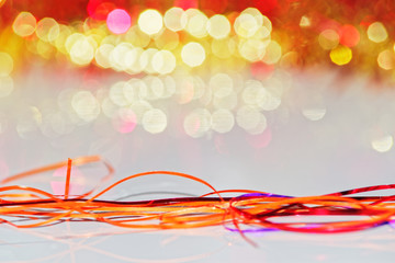 Christmas decoration from orange tinsel on white surface with copy space and blurred background