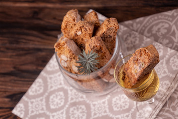 Traditional italian Christmas New Year dry cookies biscuits biscotti cantuccini in glass bowl on wooden background. Biscotti di Prato