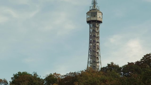 Prague, Czech Republic - September 2019: View of hill with Petrin Lookout Tower and fast moving clouds in background. 4K resolution speed up.