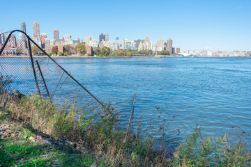 Obraz premium Shoreline of Astoria Queens New York with the East River and the Manhattan and Roosevelt Island Skyline in the background